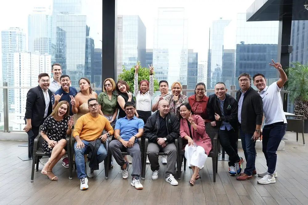 Peak Support team members are pictured gathered together on a rooftop, smiling and celebrating their culture of collaboration and community. Peak Support builds long-term partnerships through exceptional support.